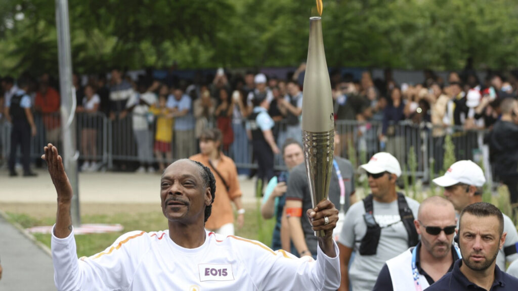 Leer Snoop Dogg carrying the Olympic torch